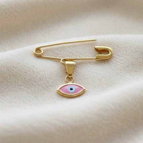 14K Gold Baptism Baby Pin Pink Evil Eye Brooch on smooth surface