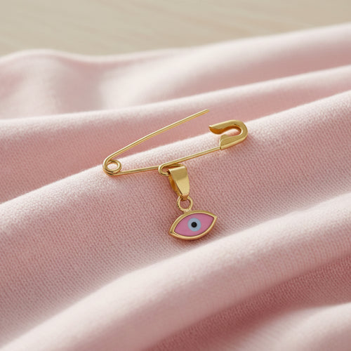 14K Gold Baptism Baby Pin Pink Evil Eye Brooch on pink silk surface