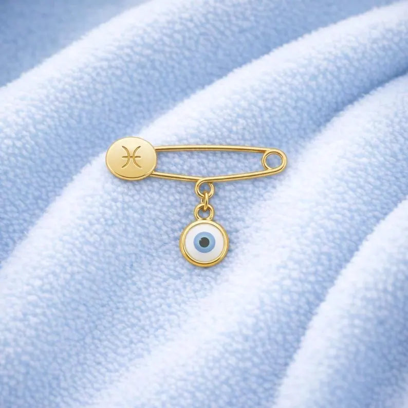 Gold Evil Eye Zodiac Safety Pin Brooch – Baby Gift on blue blanket