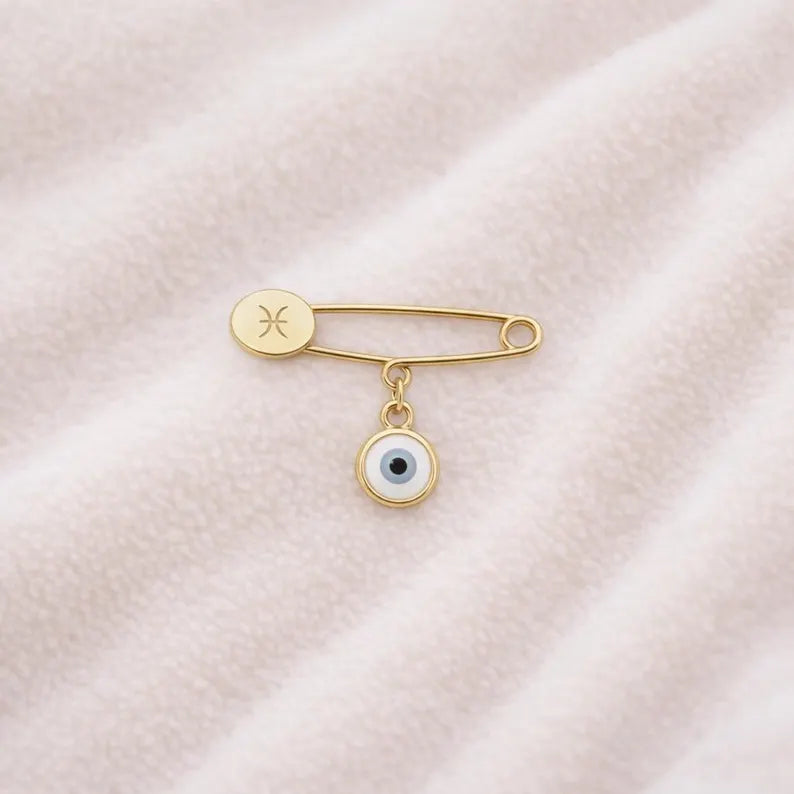 Gold Evil Eye Zodiac Safety Pin Brooch – Baby Gift on pink blanket