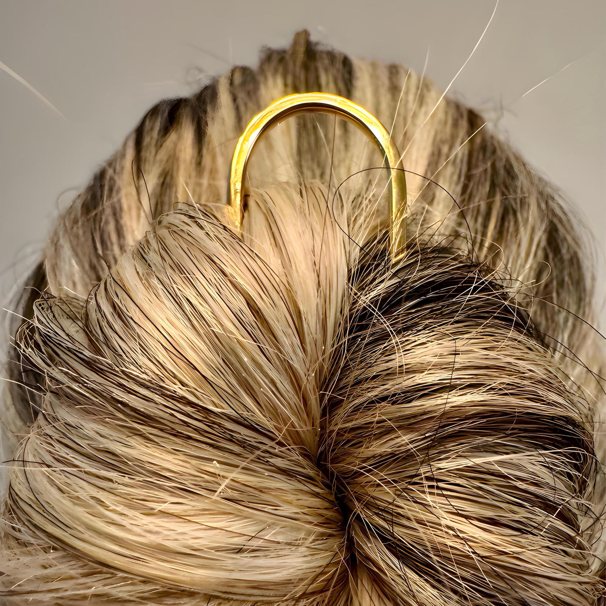 Yellow gold U-shaped French hair pin securing a twisted bun hairstyle.