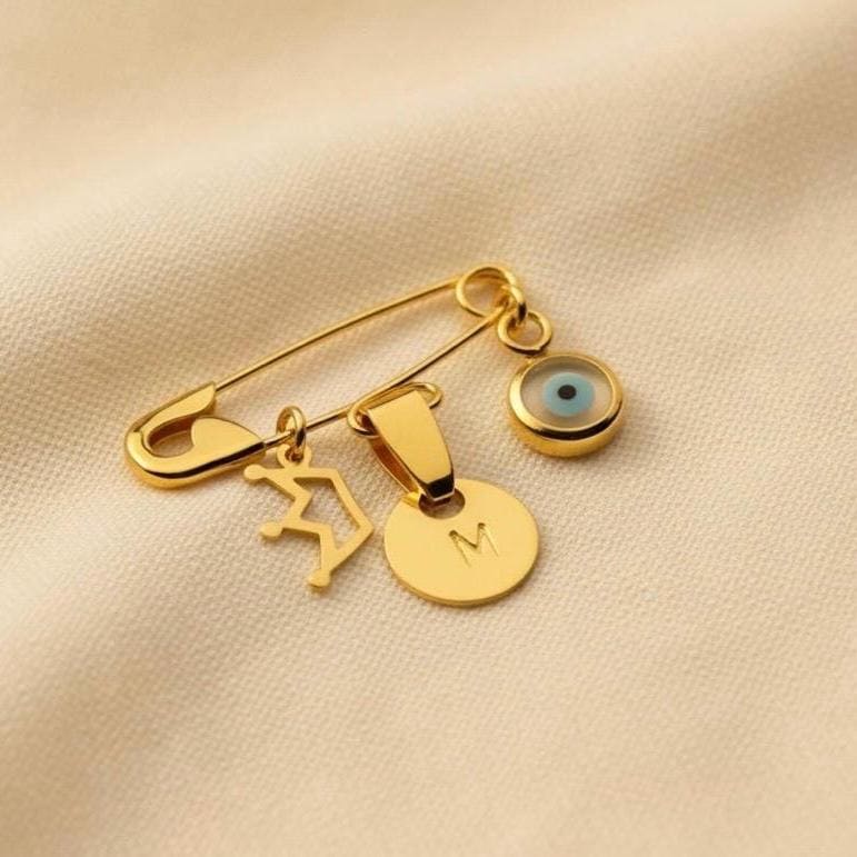 Gold Personalized Safety Baby Pin Evil Eye Brooch With Crown on smooth surface - 24jewels