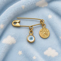 Gold Plated Silver Safety Pin Evil Eye Brooch With Hamsa Charm on a baby blanket - 24jewels