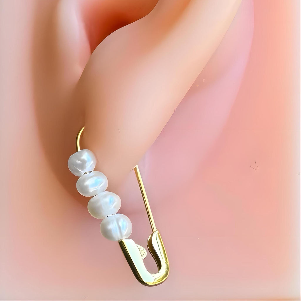 Gold plated safety pin hoop silver earring with five small white freshwater pearls on a mannequin ear.