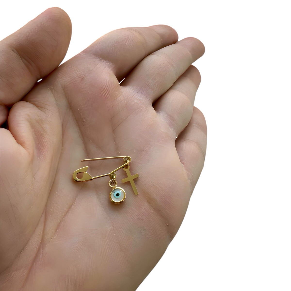 Gold Safety Pin Evil Eye Brooch with Cross held in a palm - 24jewels