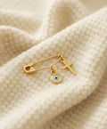 Gold Safety Pin Evil Eye Brooch with Cross on a blanket - 24jewels