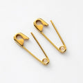 yellow gold safety pin earrings with polished finish, 3/4 inch length, minimalist punk style on white background .