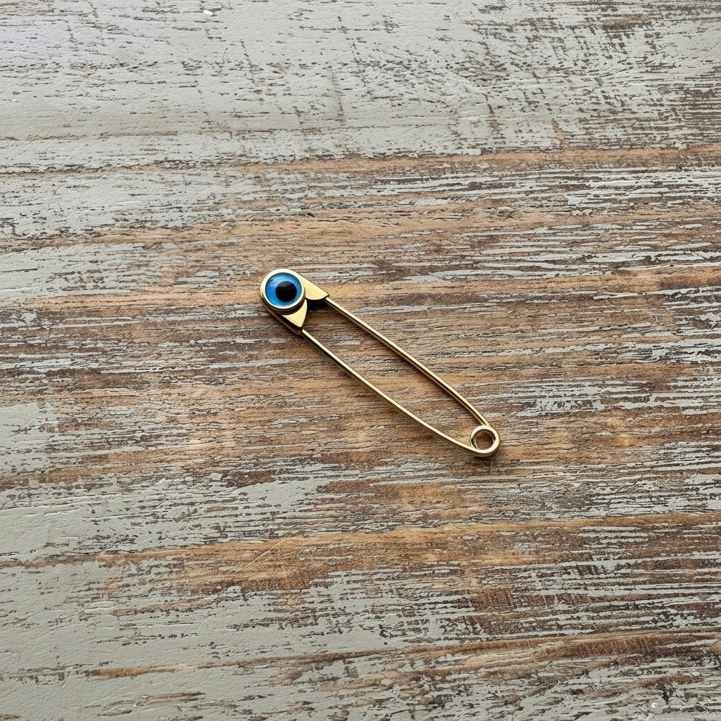 Gold Evil Eye Safety Pin Brooch – Nazar Protection Jewellery on wooden surface - 24jewels