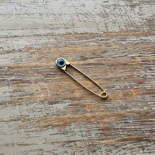 Gold Evil Eye Safety Pin Brooch – Nazar Protection Jewellery on wooden surface - 24jewels