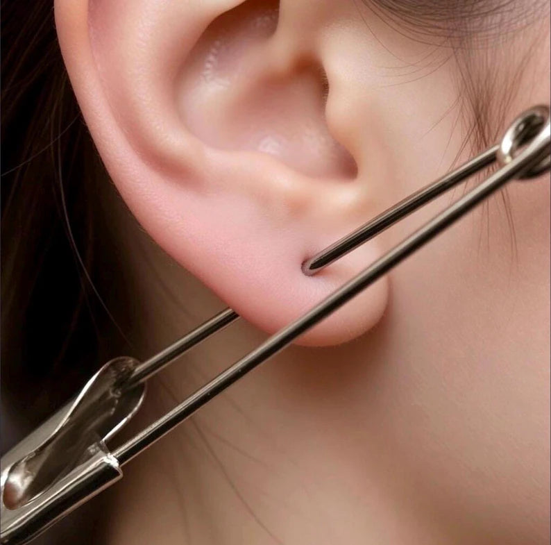 Large sterling silver safety pin earring measuring 2.5 inches worn on earlobe.