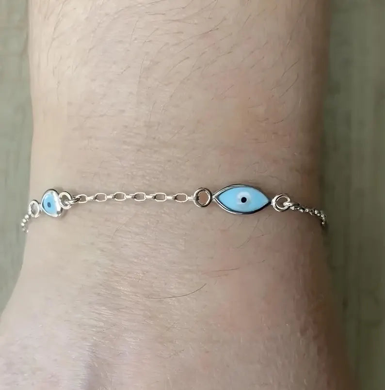 Sterling silver dainty chain bracelet with blue evil eye charms and small heart details.