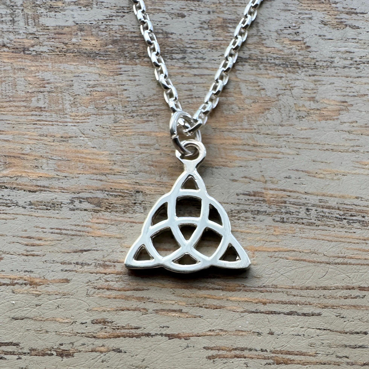 Sterling silver necklace with a minimalist Celtic triquetra knot pendant on a delicate chain.