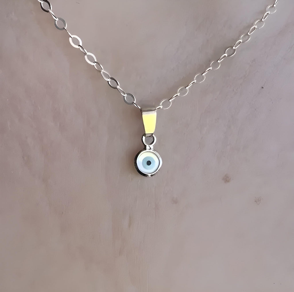 Sterling silver necklace with a small round evil eye pendant on a delicate chain.