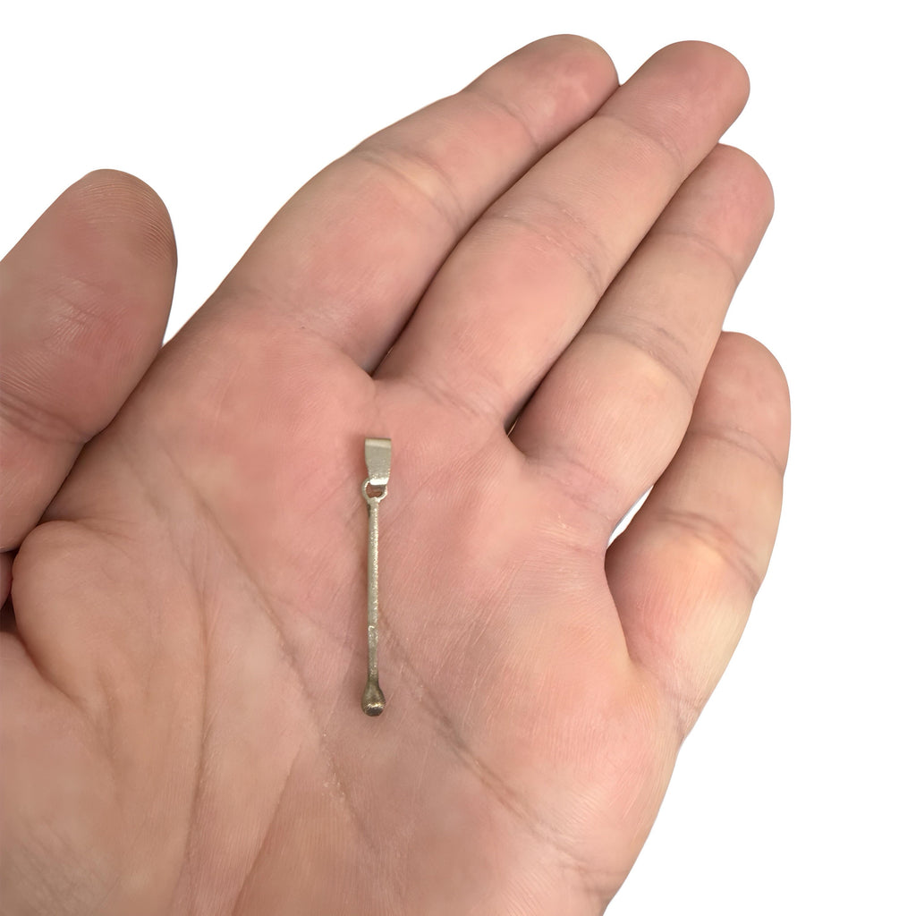 Gold plated sterling silver matchstick pendant resting on an open palm.