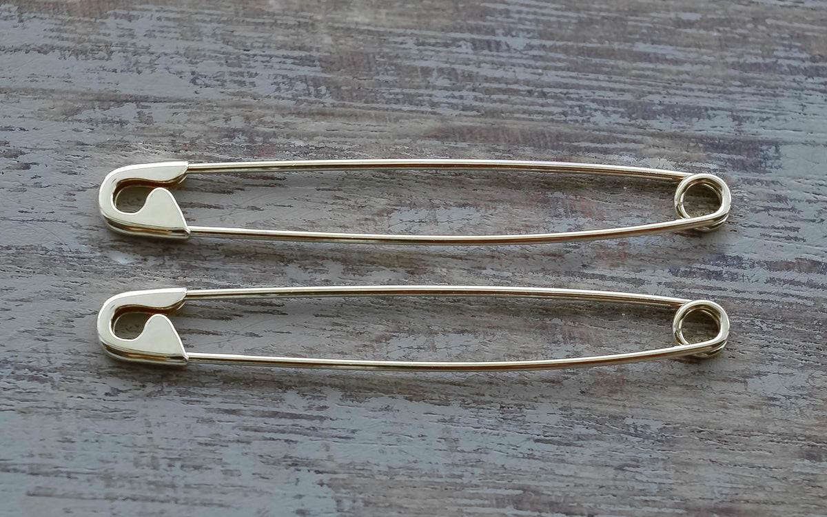 Pair of 1.75-inch sterling silver safety pin earrings with a shiny, smooth finish.