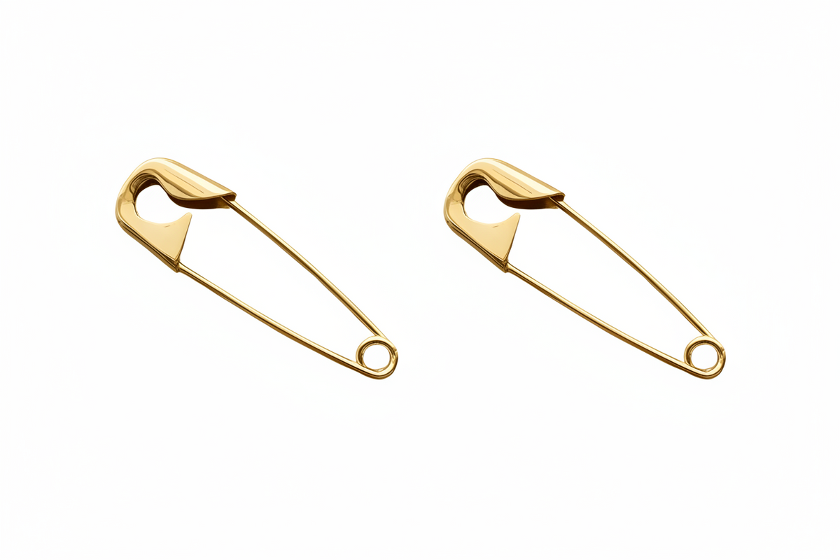 Pair of large gold-plated safety pin earrings 2 inches with smooth, polished finish and thin wire design on white background . 