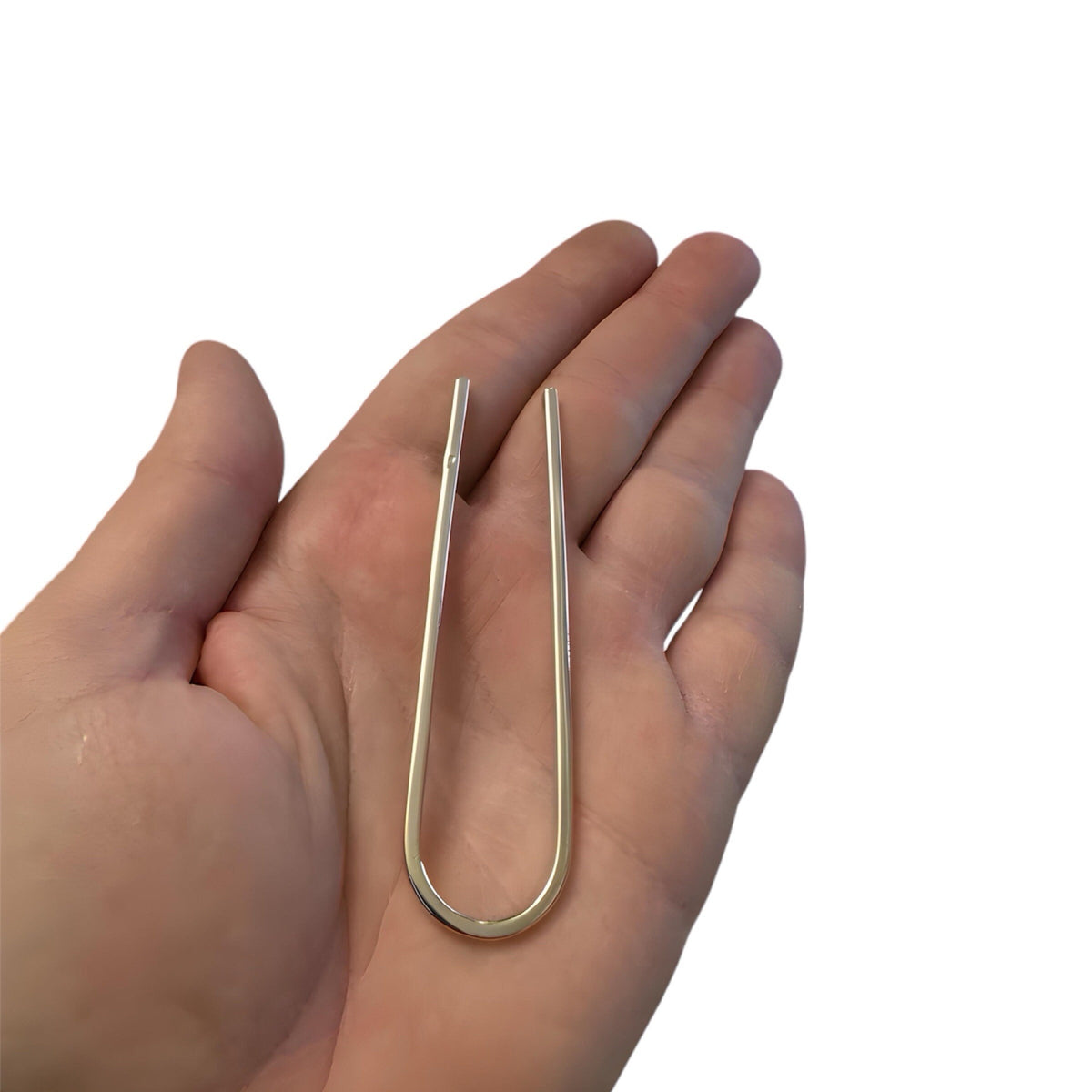 Slim U-shaped gold metal hair pin bun holder, 3.5 inches long, held in palm.