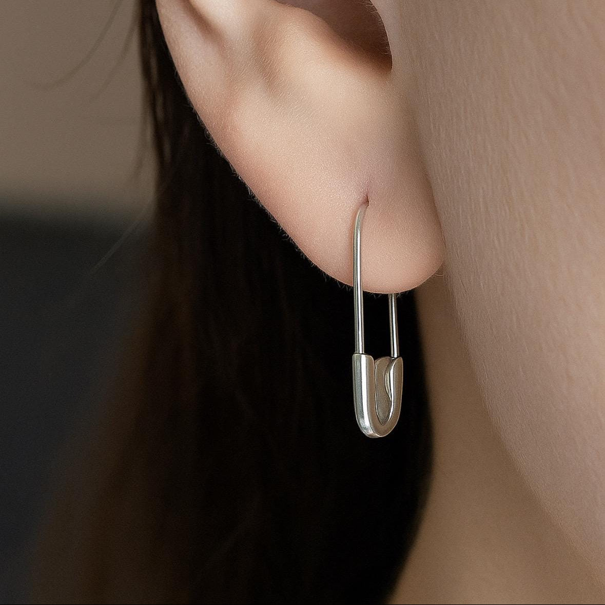 White gold safety pin hoop earring worn in pierced ear, minimalist design, 3/4 inch length.